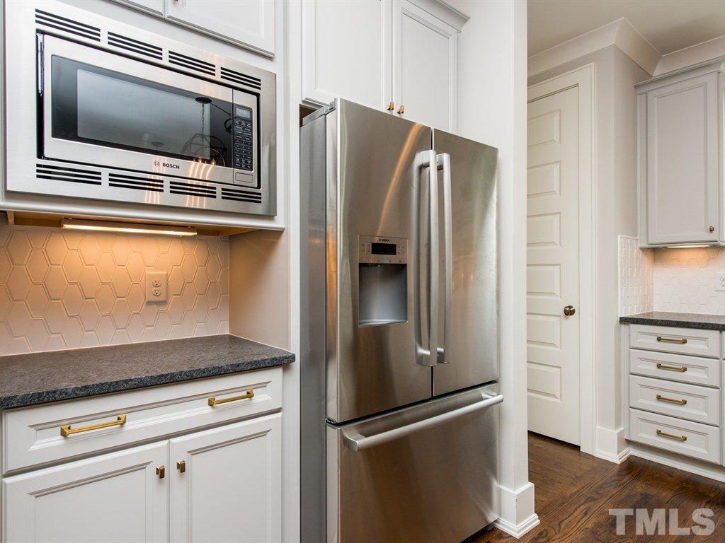 102 Revival Way Raleigh, NC 27608 - Photo 7 of 25 a metallic refrigerator freezer sitting in a kitchen