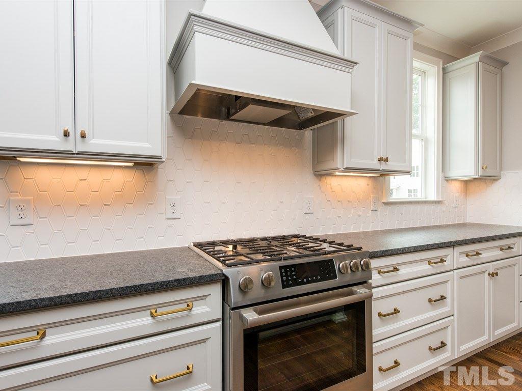 102 Revival Way Raleigh, NC 27608 - Photo 9 of 25 a kitchen with granite countertop white cabinets and white appliances