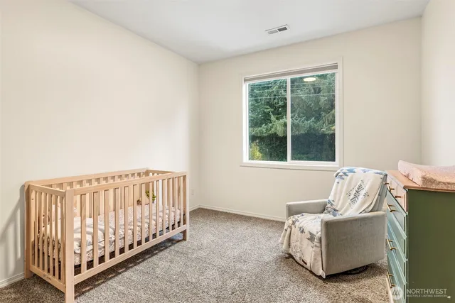 a bedroom with a bed and painting on the wall