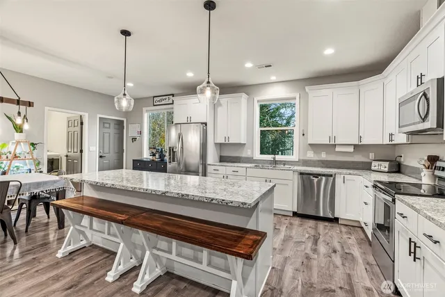 a large kitchen with kitchen island a sink dining table and chairs