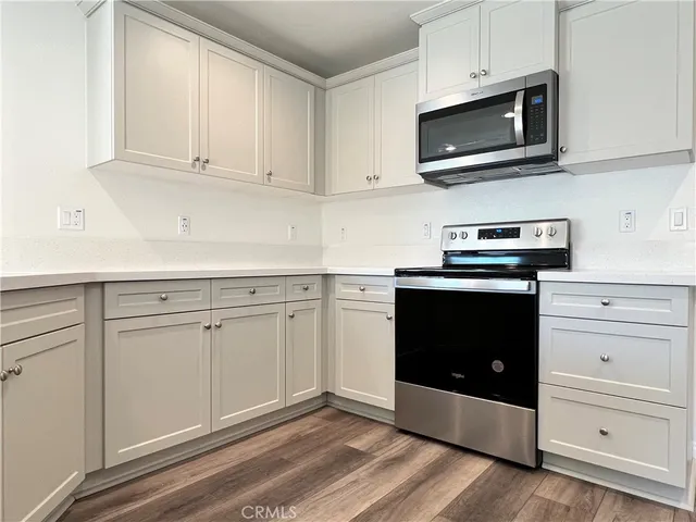 a kitchen with white cabinets and stainless steel appliances