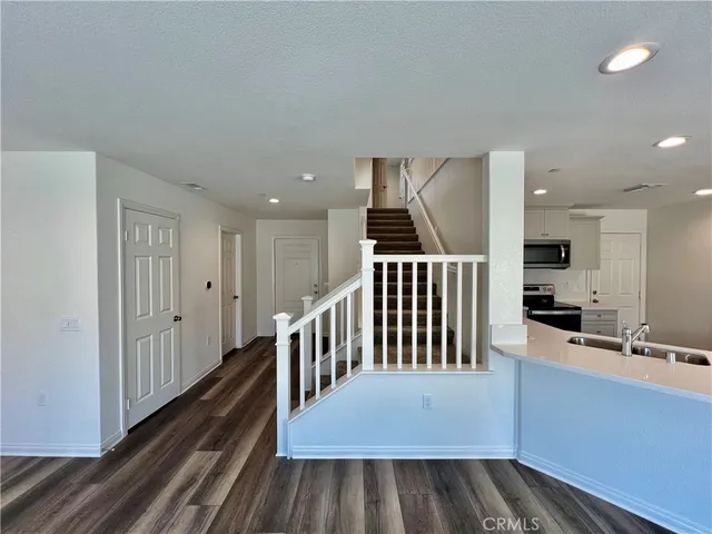 a view of a hallway with wooden floor and staircase
