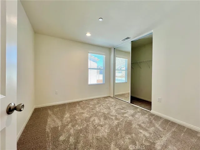 en empty room with sliding door and wooden floor