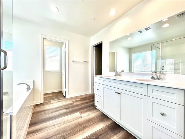 a spacious bathroom with a tub shower and sink