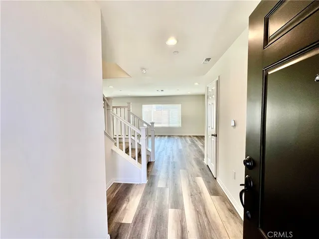 a view of a hallway with wooden floor and staircase