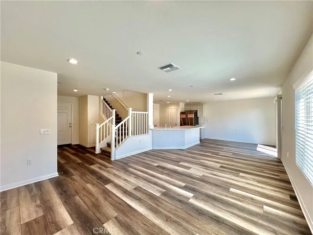 a view of a bedroom with wooden floor and stairs