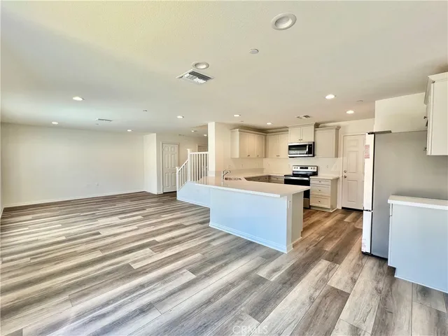 a kitchen with stainless steel appliances kitchen island granite countertop a refrigerator and a stove top oven