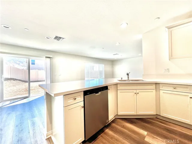 a kitchen with stainless steel appliances granite countertop a sink and cabinets with wooden floor