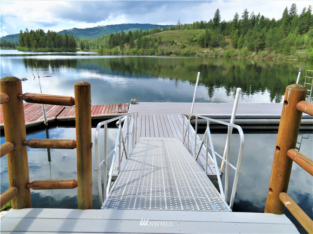 58 Petes Retreat Road Republic, WA 99166 - Photo 26 of 32 a view of a lake with couches wooden fence