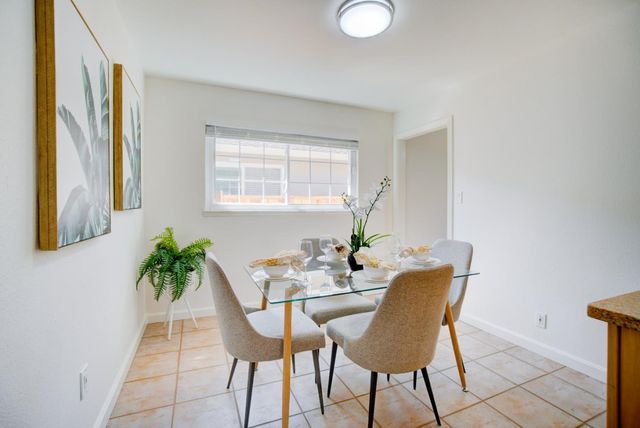 a view of a dining room with furniture and a potted plant
