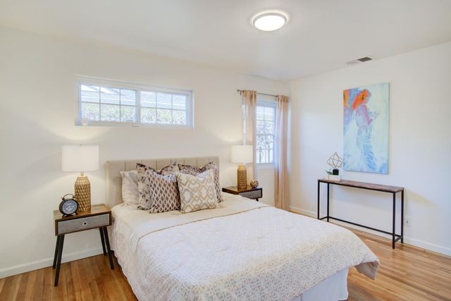 a bedroom with a bed and wooden floor