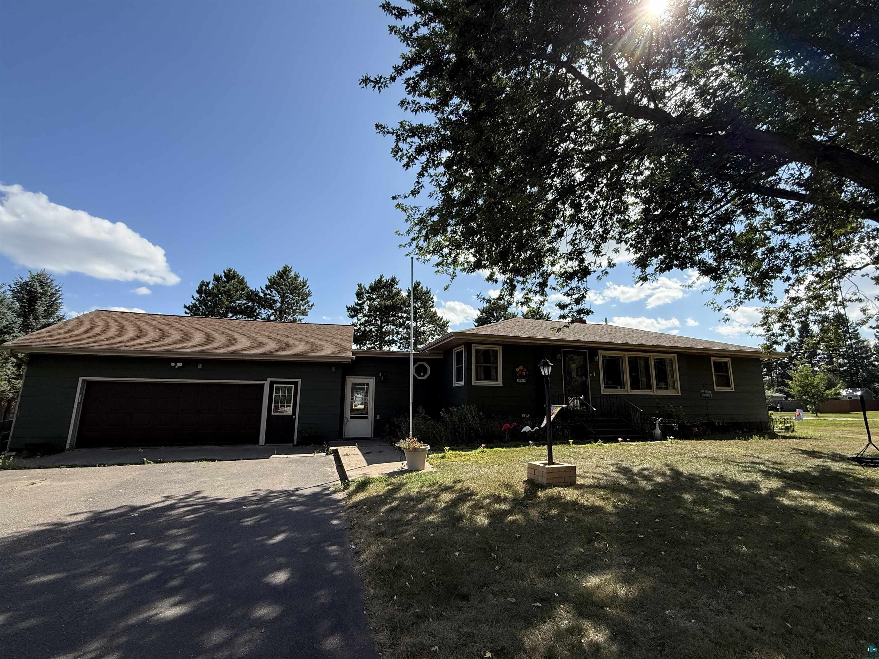 Ranch-style exterior with dark siding and a prominent attached garage