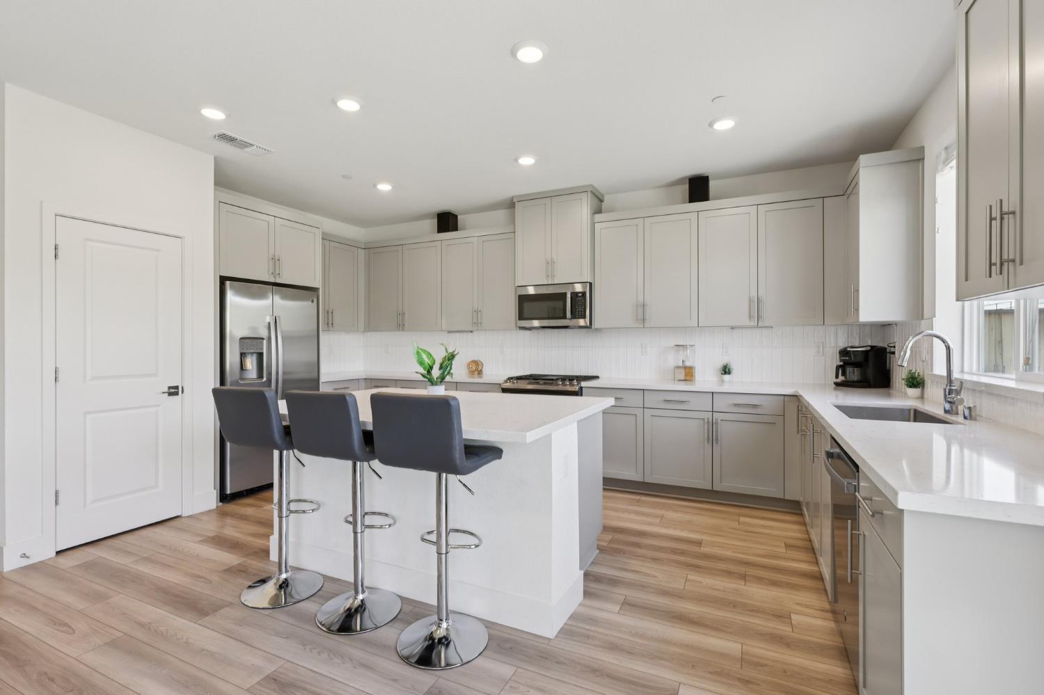 3946 Needham Street Tracy, CA 95377 - Photo 8 of 40 a kitchen with white cabinets and stainless steel appliances