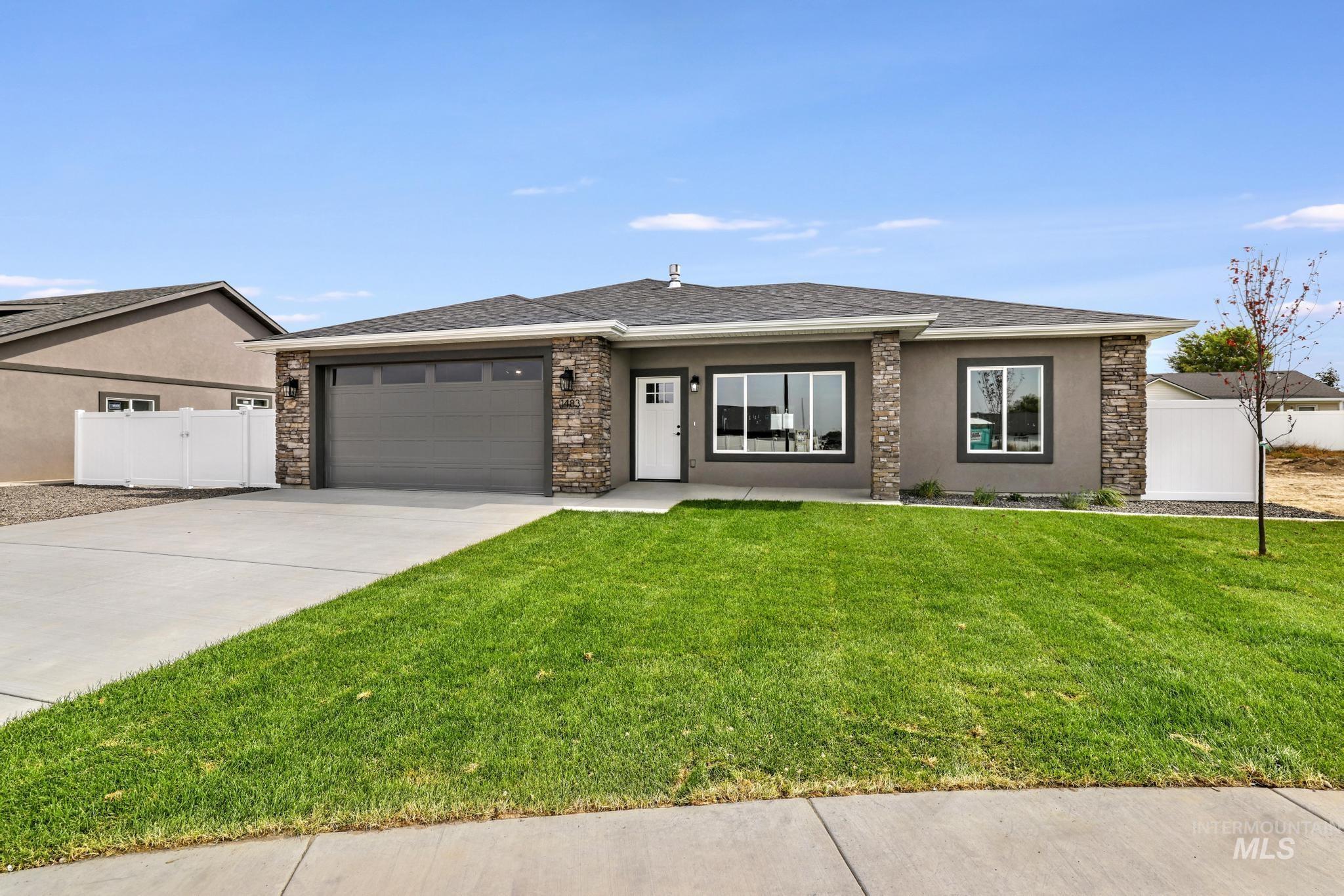 1441 Haizlee Way Twin Falls, ID 83301 - Photo 1 of 26 Prairie-style house with driveway, an attached garage, stucco siding, a gate, and stone siding