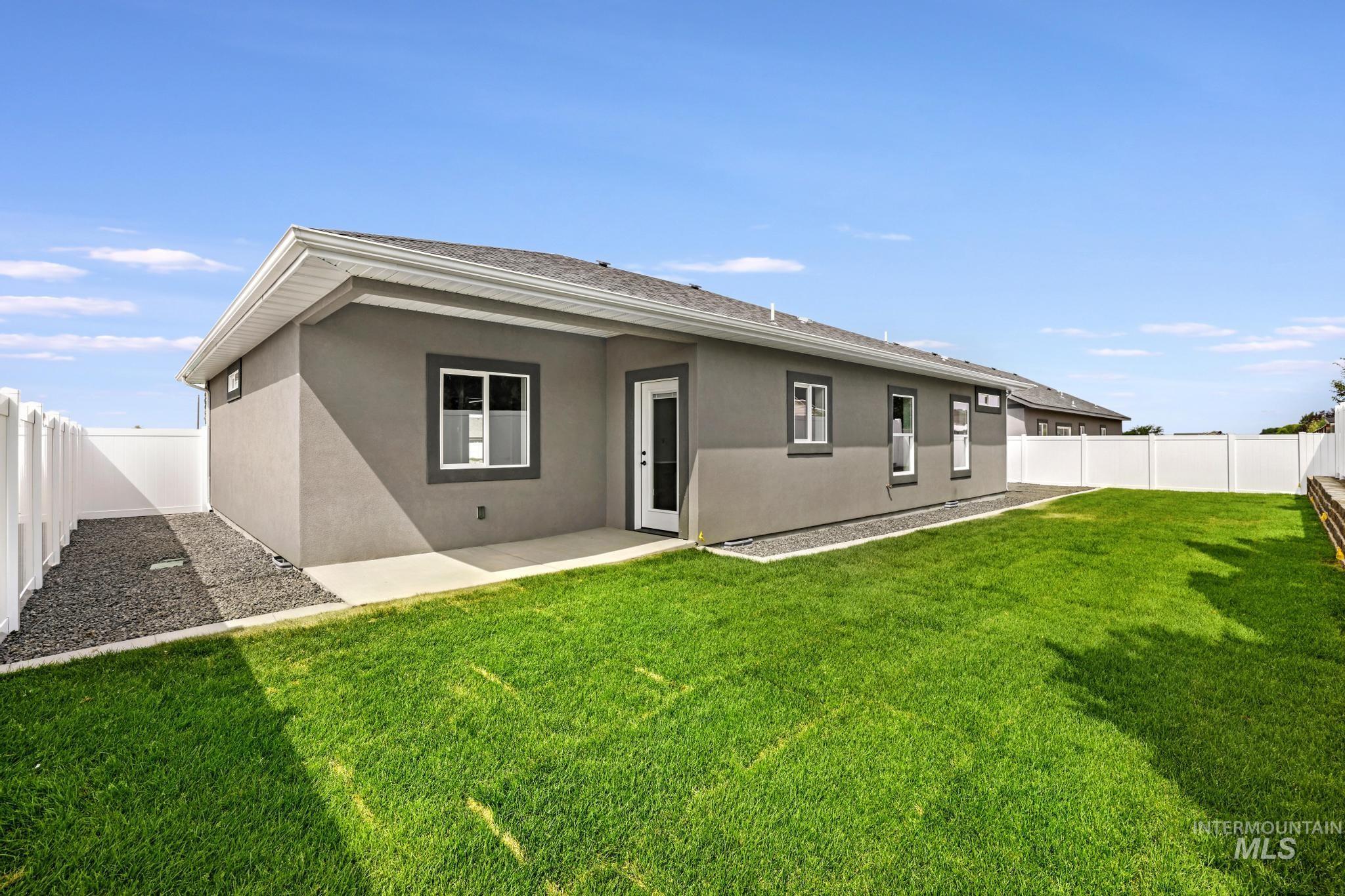 1441 Haizlee Way Twin Falls, ID 83301 - Photo 21 of 26 Rear view of house with stucco siding, a fenced backyard, and a patio area