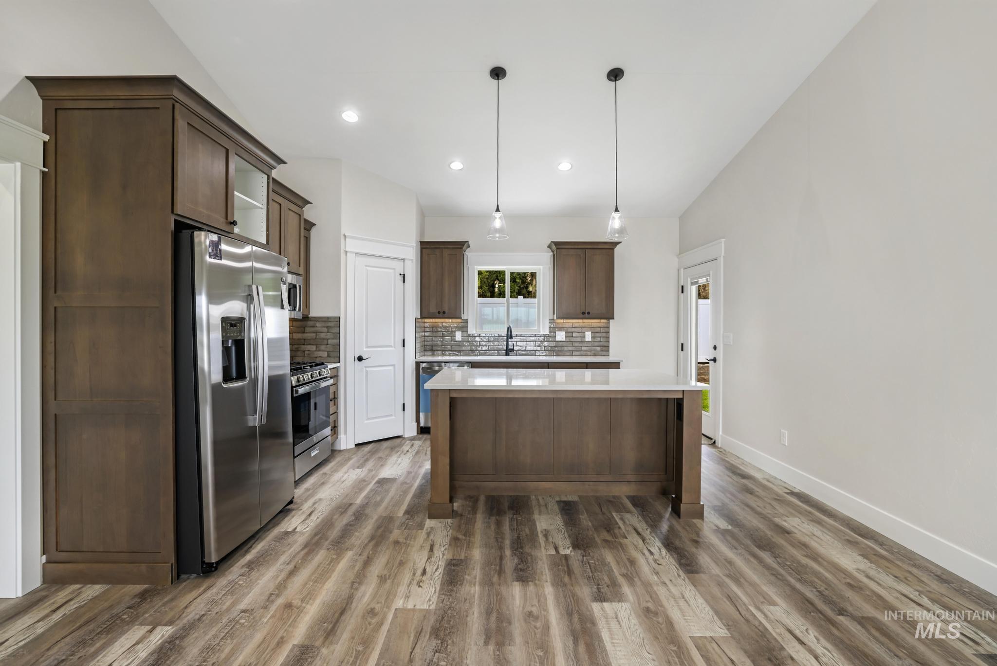 1441 Haizlee Way Twin Falls, ID 83301 - Photo 3 of 26 Kitchen with dark wood finish cabinets, stainless steel appliances, a center island, and pendant lighting