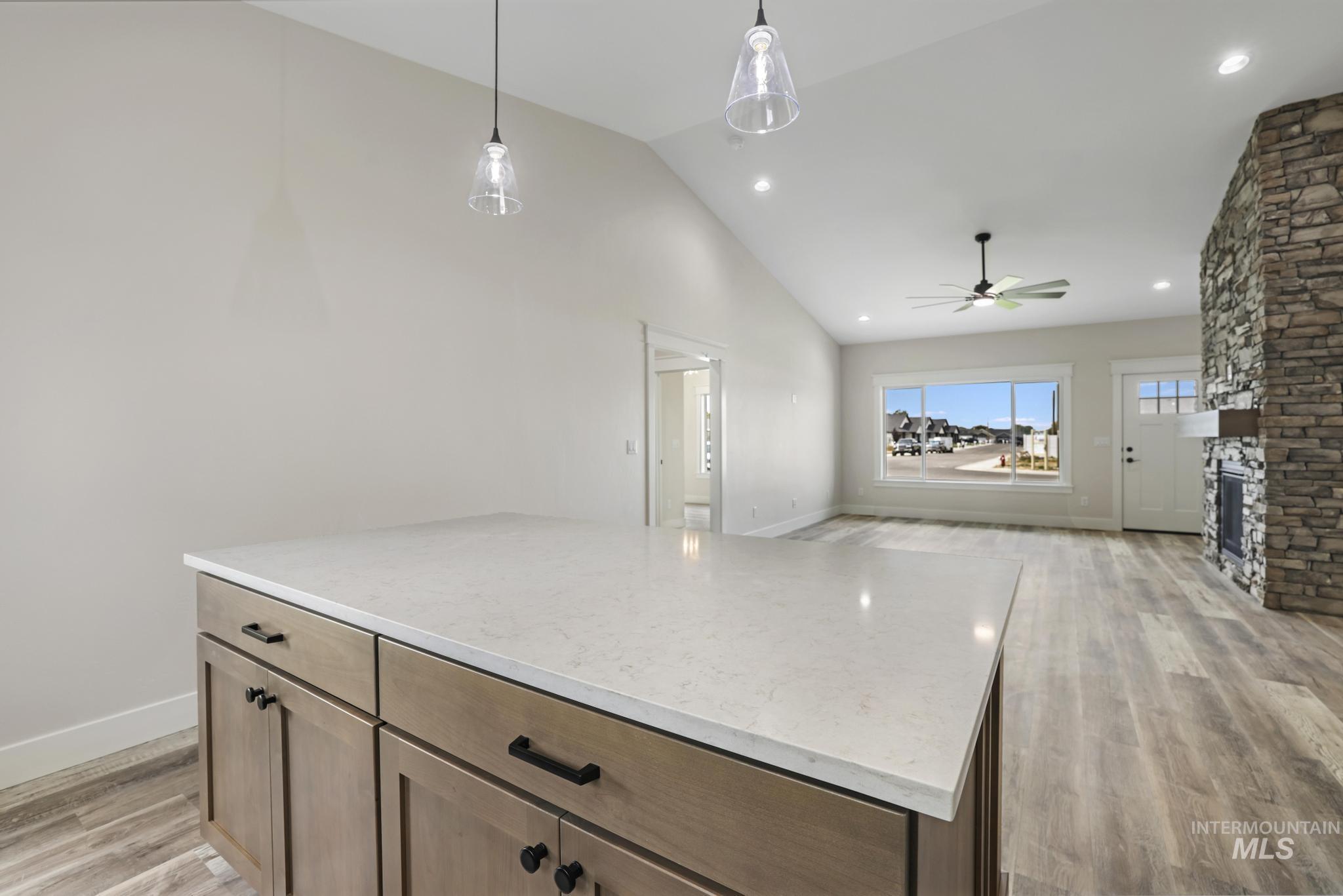 1441 Haizlee Way Twin Falls, ID 83301 - Photo 26 of 26 Kitchen featuring a kitchen island, light wood-type flooring, pendant lighting, open floor plan, and vaulted ceiling