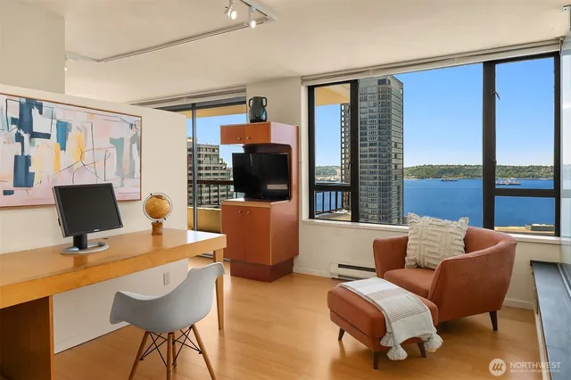 a living room with furniture a flat screen tv and large windows