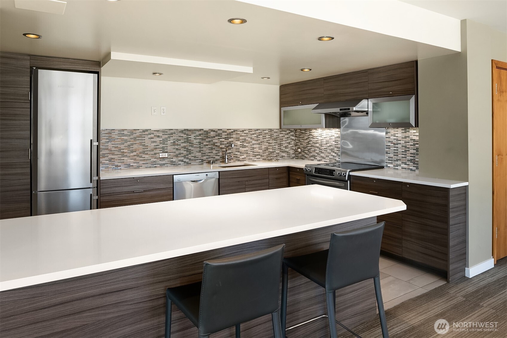 2201 3rd Avenue, Unit 2003 Seattle, WA 98121 - Photo 32 of 38 a kitchen with a wooden floor and white cabinets