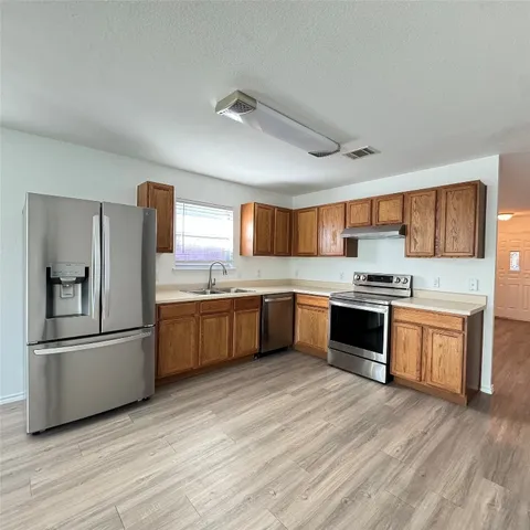 a large kitchen with a stove top oven and refrigerator