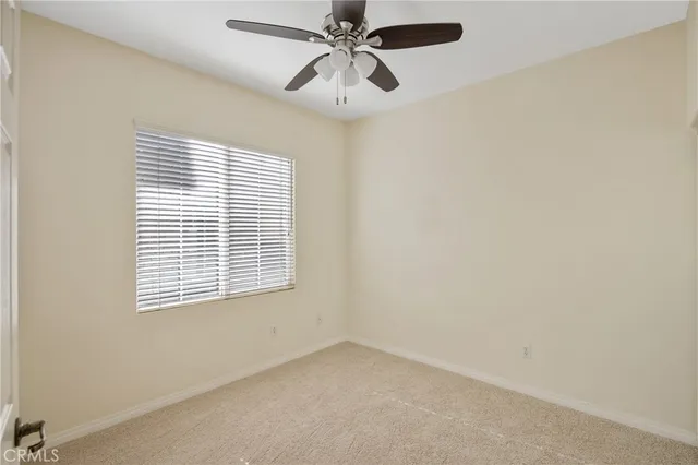 an empty room with a window and a fan