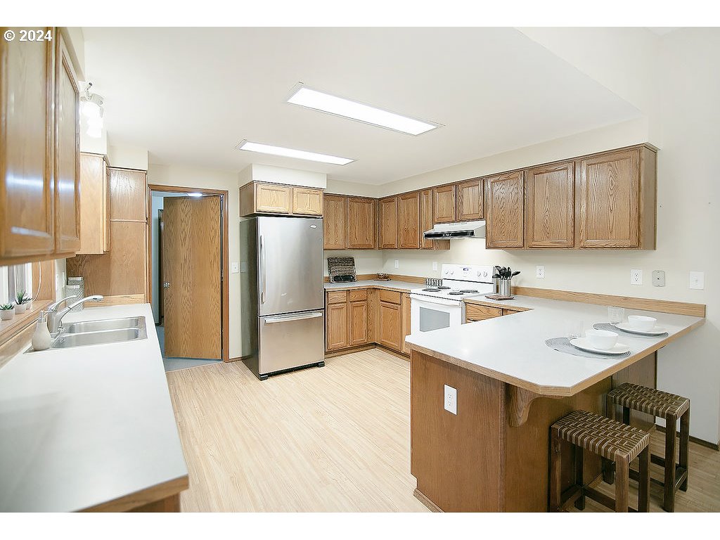59 Whitewater Road Longview, WA 98632 - Photo 10 of 39 a kitchen with a refrigerator a sink and cabinets