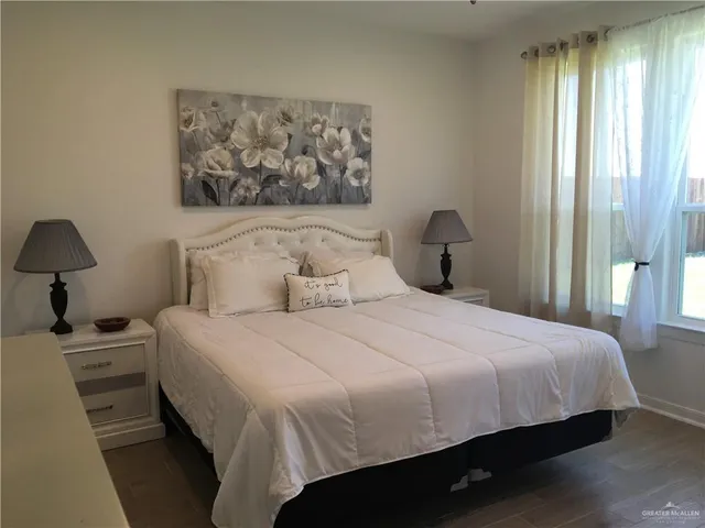 a bedroom with a bed and a painting on the wall