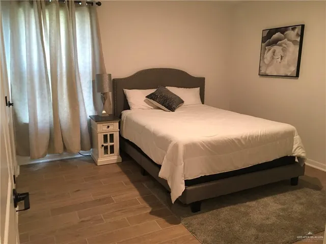 a large bed sitting in a bedroom next to a window