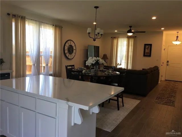 a kitchen with kitchen island granite countertop a sink cabinets and wooden floor
