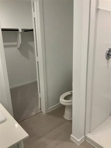a white toilet sitting next to a shower