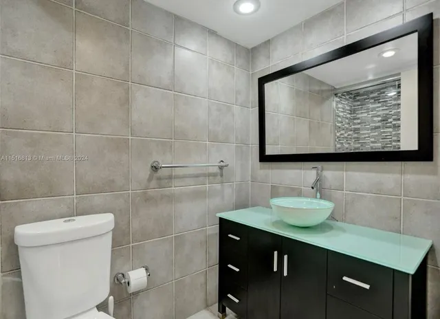 a bathroom with a sink a toilet and a mirror