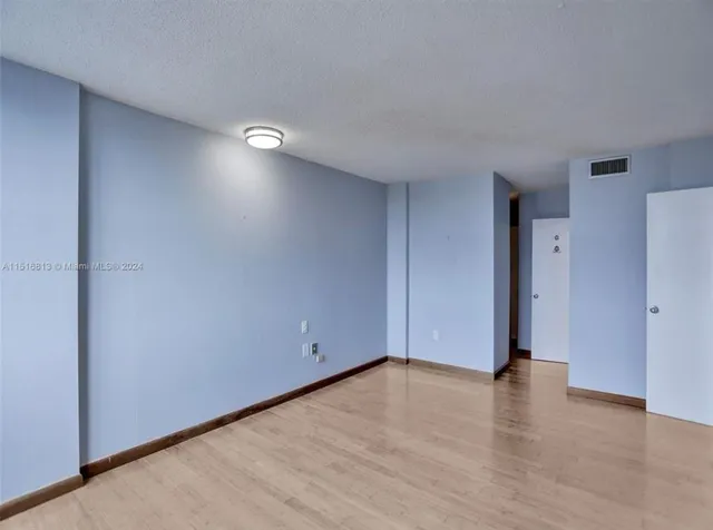 a view of an empty room with wooden floor