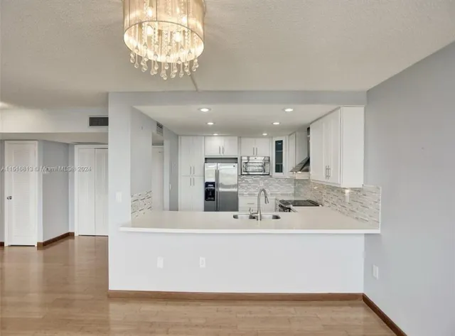 a view living room with kitchen island sink and refrigerator
