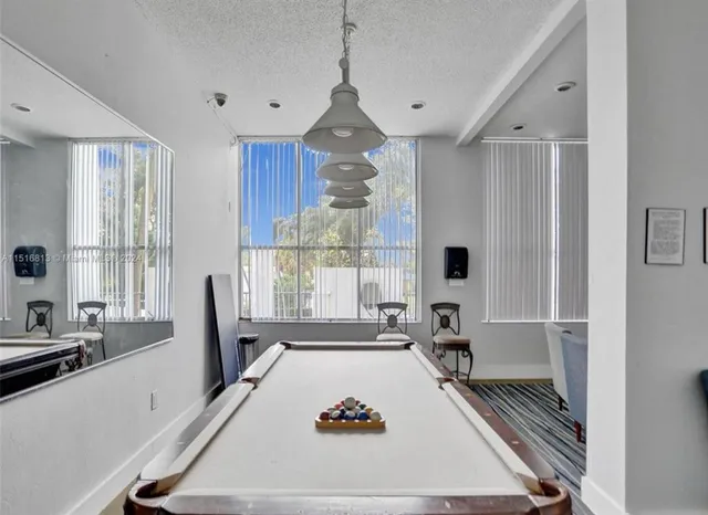 a room with pool table and windows