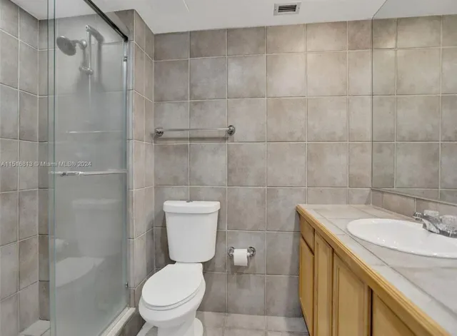 a bathroom with a sink a toilet and a shower