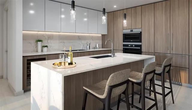a kitchen with stainless steel appliances kitchen island a table chairs and a refrigerator
