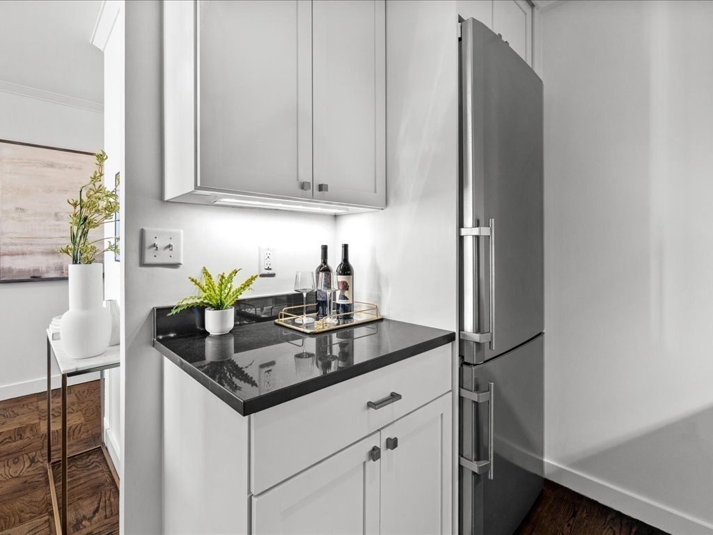 65 East India Row, Unit 33A Boston, MA 02110 - Photo 14 of 36 a kitchen with stainless steel appliances granite countertop a sink a refrigerator and a granite counter tops