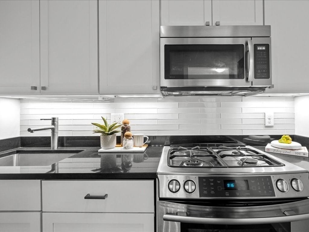 65 East India Row, Unit 33A Boston, MA 02110 - Photo 16 of 36 a stove top oven sitting inside of a kitchen