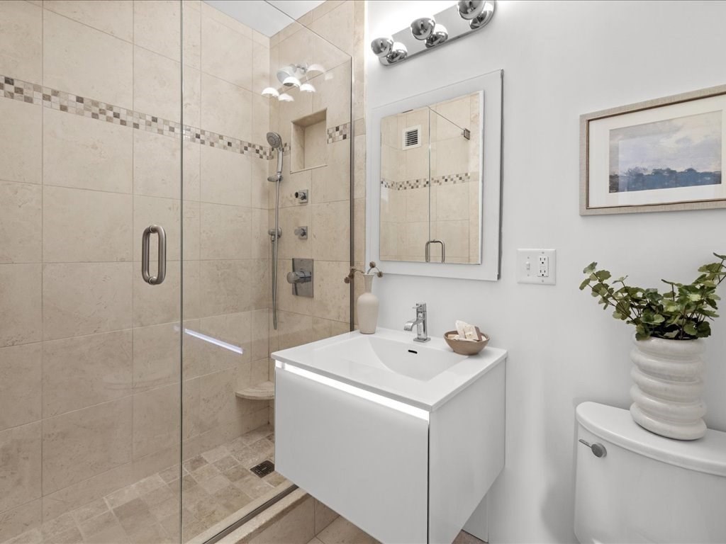 65 East India Row, Unit 33A Boston, MA 02110 - Photo 21 of 36 a bathroom with a sink a toilet and shower