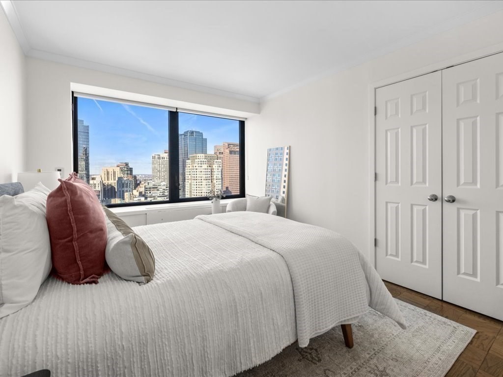 65 East India Row, Unit 33A Boston, MA 02110 - Photo 25 of 36 a bed sitting in a bedroom next to a window