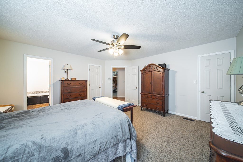 200 Lake Amah Lee Road Hampton, GA 30228 - Photo 23 of 29 a bedroom with a bed and a chandelier