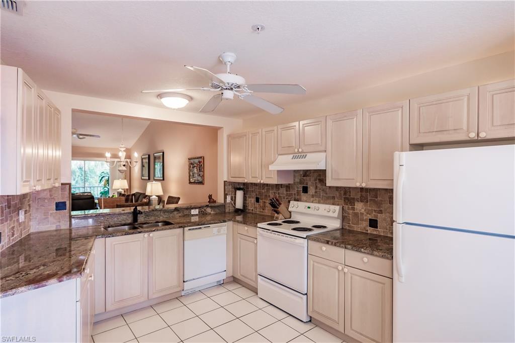 320 Gabriel Circle, Unit 3608 Naples, FL 34104 - Photo 6 of 32 a kitchen with white cabinets and white appliances