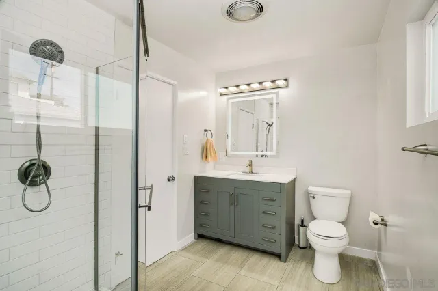 a bathroom with a toilet sink shower and mirror