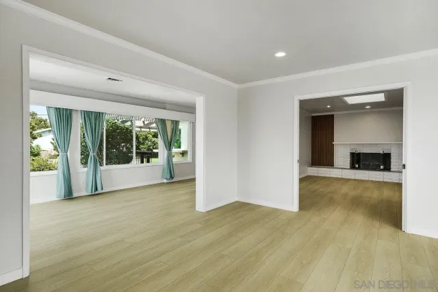 a view of empty room with wooden floor and fireplace