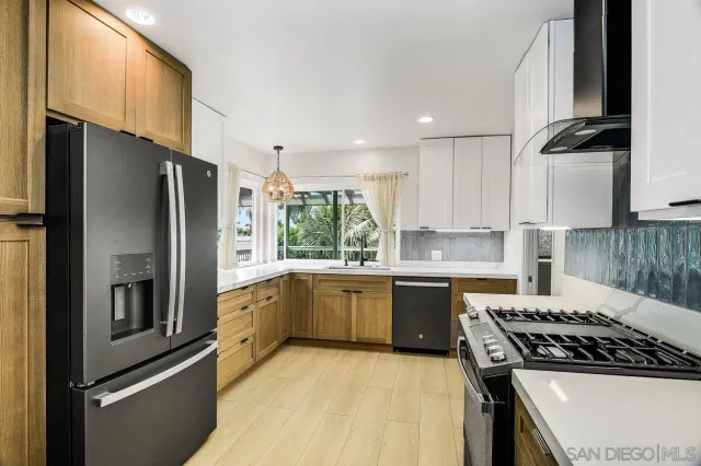 a kitchen with a refrigerator a sink and a stove top oven