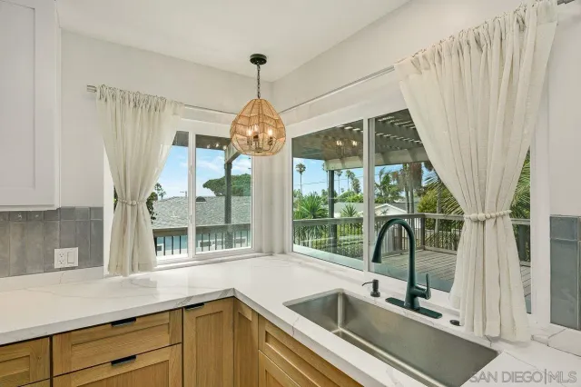 a view of a kitchen with a sink and large window