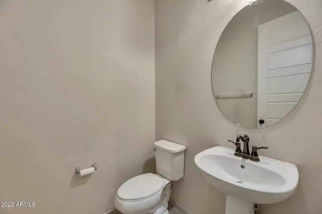 a bathroom with a sink a toilet and a mirror