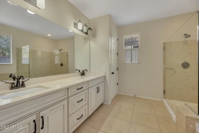 a spacious bathroom with double sink and a mirror