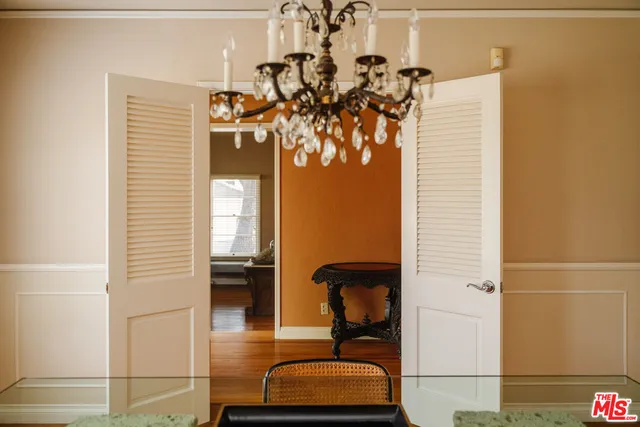 a view of a dining room with furniture a chandelier and wooden floor