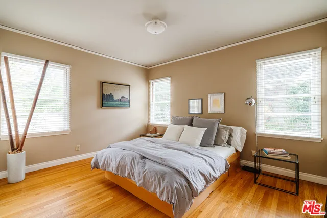 a bed sitting in a bedroom next to a window
